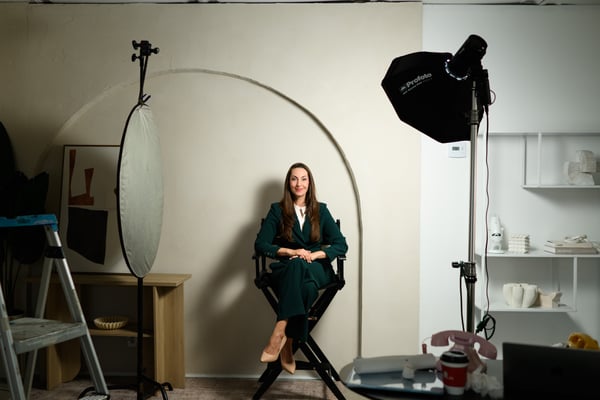 Vanessa Van Edwards seated in director chair on set