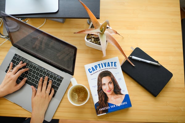 Overhead desk scene with laptop and Captivate book