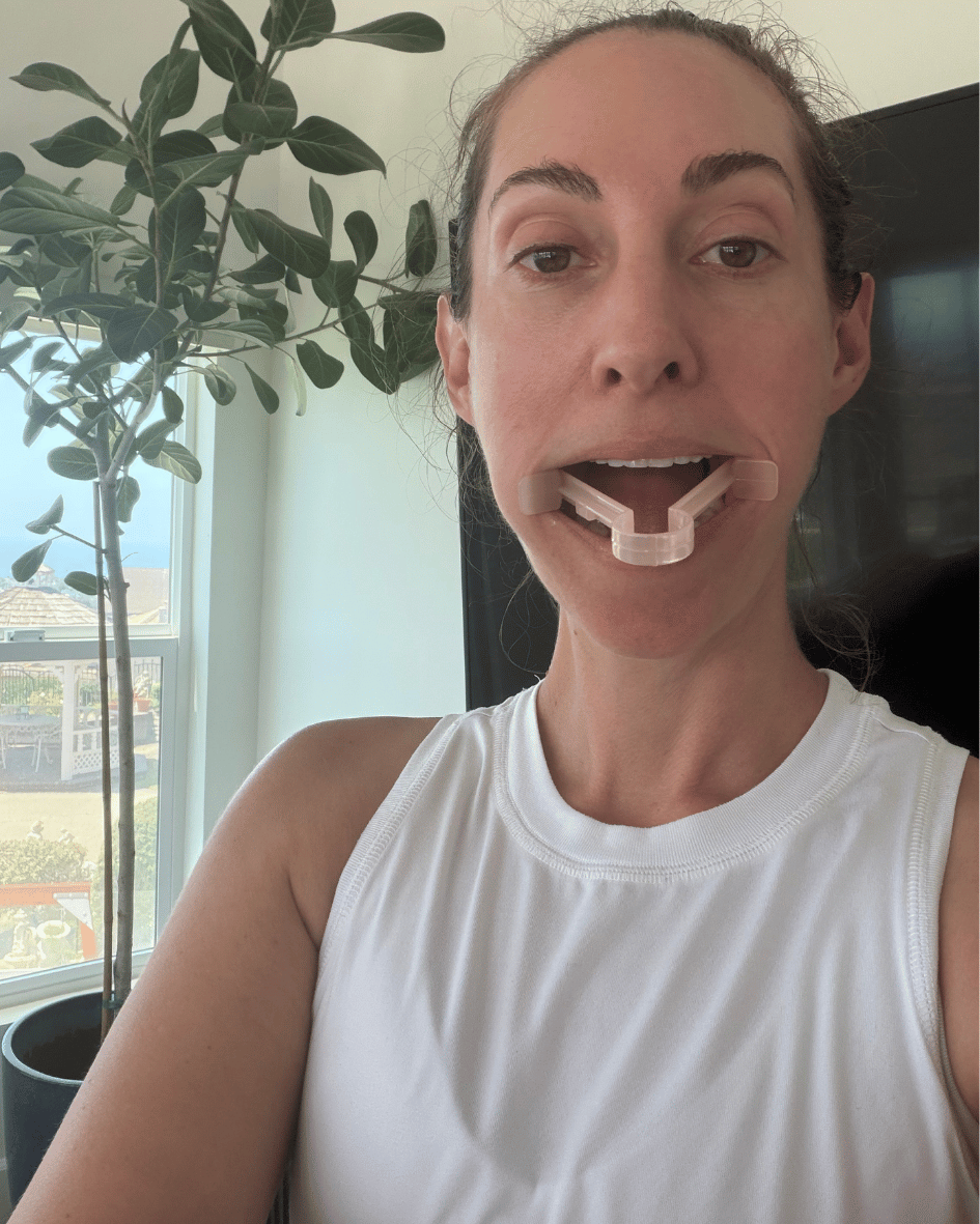 A small clear jaw exerciser held between the teeth.