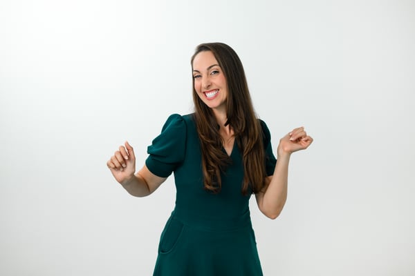 Vanessa Van Edwards dancing joyfully in teal dress