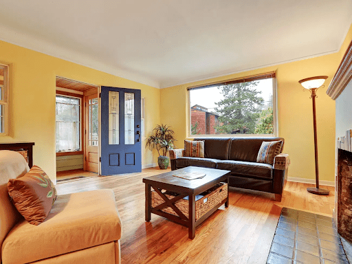 An image of a living room with yellow colored walls that describe the quote from Amy Wax that said "Sweet yellows can improve one’s mood…Using a softer yellow creates a feeling in the space that is sunny, warm, and spirited." This is an example of color psychology.
