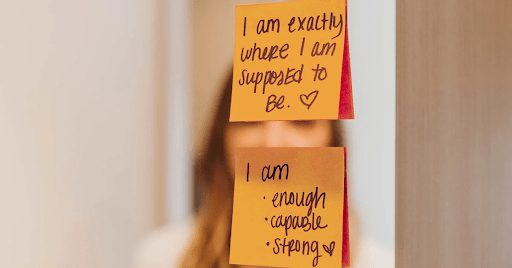 An idea for managing social anxiety, that shows two sticky notes on a bathroom mirror with positive affirmations on them. The goal is to read these aloud each day.