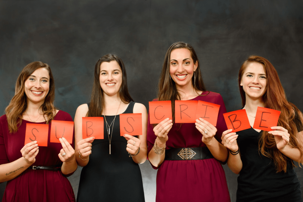 Vanessa and her friends hold up pages that spell out "Subscribe"