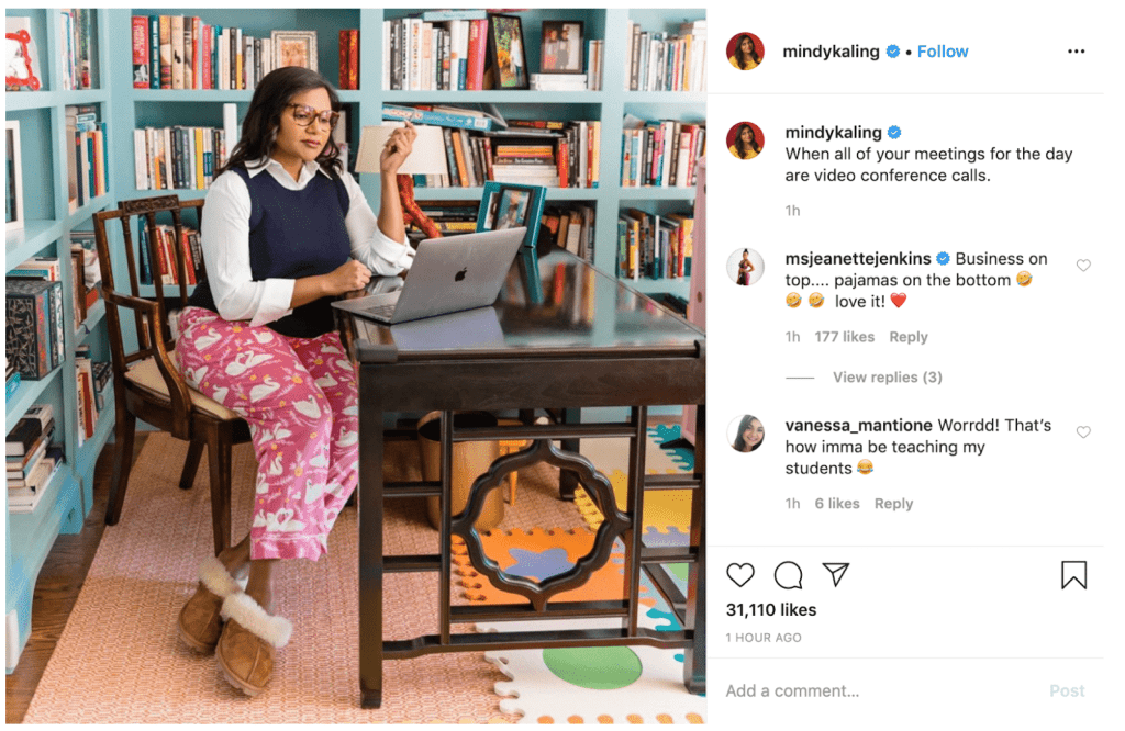 A woman is working at home on her laptop. She is wearing a nice collared shirt and vest on top, but she is wearing pajamas and fluffy slippers below.