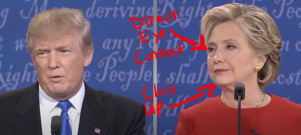 Clinton looks at Trump while posing for the camera.