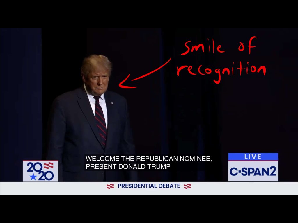 Trump walks on stage while flashing a smile