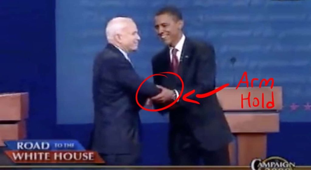Obama touches McCain's arm.