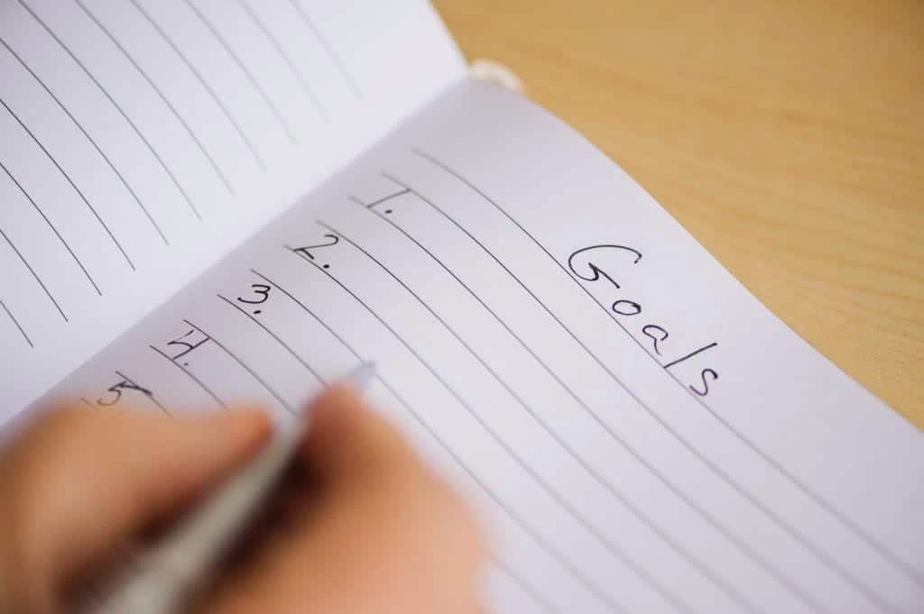 C-level executive's hand, writing a goal list