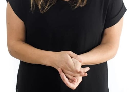 Hand clasping, which is one of many closed body language examples