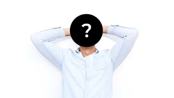 man with his hands behind his head and face cover by a question mark