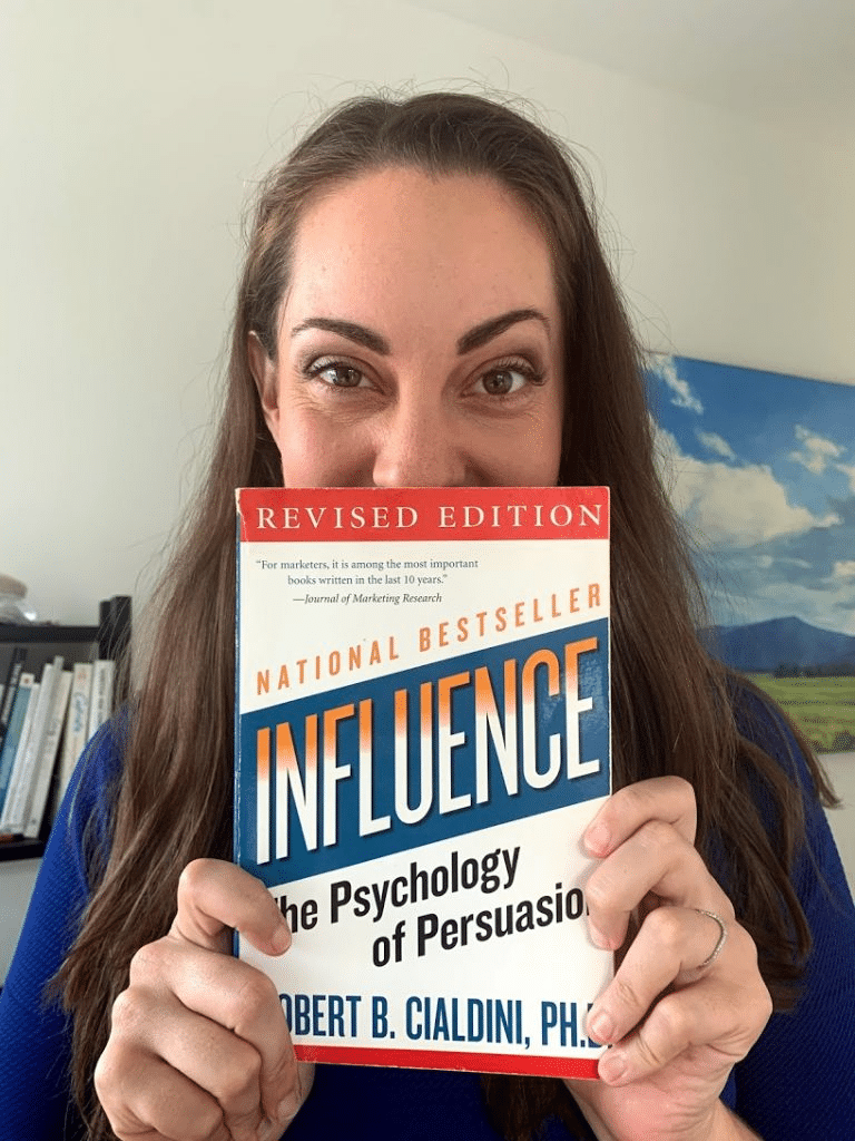 Vanessa van Edwards holding the book Influence: The Psychology of Persuasion