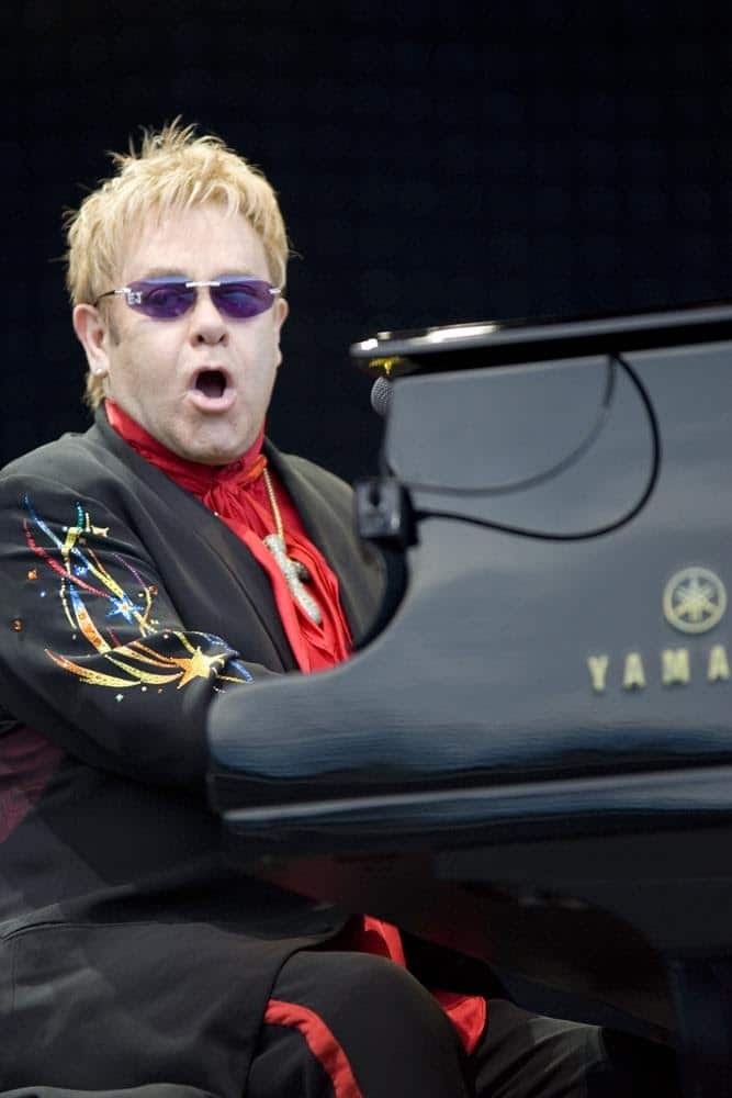 Elton John playing the piano and singing