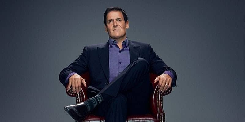 Mark Cuban with his legs in the figure 4 position