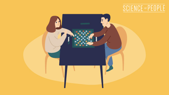 A couple sits together and plays board games.