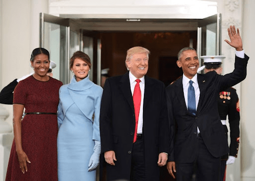 Donald Trump and Barack Obama along with their wives smile at the distance.