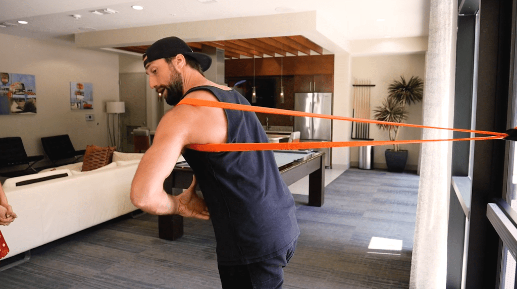 Pulling a resistance band over a shoulder.