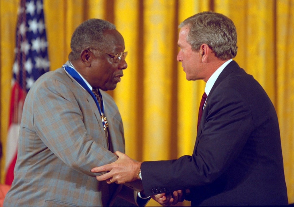 Image of President Bush shaking hands with baseball legend Hank Aaron, in a dominant way