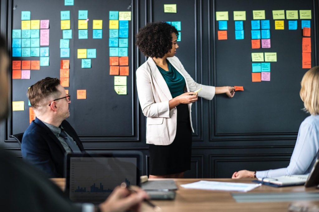 A picture of a woman using sticky notes in a presentation.