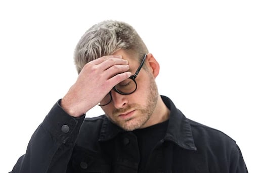 An image of a man with his hand on his forehead and his eyes closed, which is the shame cue. This is when someone touches the sides of their forehead, it is a subtle form of shame. We do this to block out something embarrassing or that we do not want to talk about. This relates to the article which is about social perceptiveness.