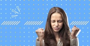A woman looking angry who is clenching her fists and closing her eyes hard. This relates to the article on how to control your anger in a relationship.
