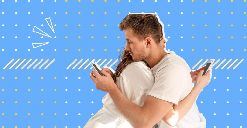 An image of a man and a woman hugging and both are looking a their phones behind the others back. This relates to the article on why do people cheat.