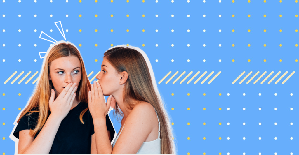 The two girls are whispering to each other.